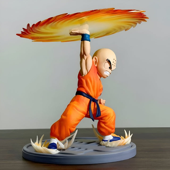 Une figurine de Krilin, un personnage de Dragon Ball Z, en train de lancer un Kamehameha. Il est vêtu d'un gi orange et d'une ceinture bleue. Il a les cheveux rasés et les yeux bleus. Le Kamehameha est une attaque énergétique puissante qui est utilisée par les Saiyans.,FI-5610950031
