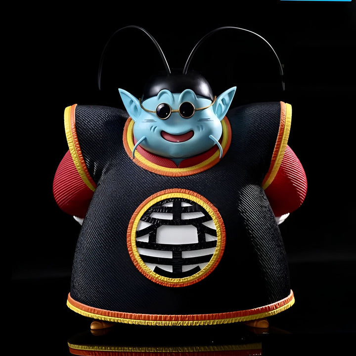 Une figurine de collection de King Kai, un personnage de la série animée Dragon Ball Z. Il est représenté avec son apparence humanoïde bleue, portant son vêtement noir et rouge caractéristique avec le symbole de la planète Terre sur le devant.,FI-1264161948