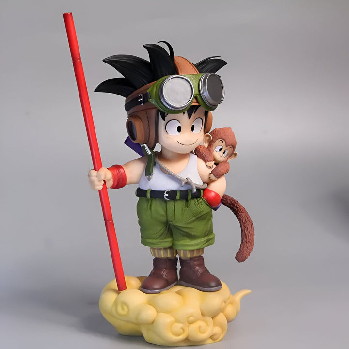 Une figurine de Son Goku, un personnage de Dragon Ball, est debout sur un nuage. Il porte une combinaison verte et des lunettes. Il tient un bâton dans sa main droite et a un singe sur son épaule gauche.,FI-2444534719