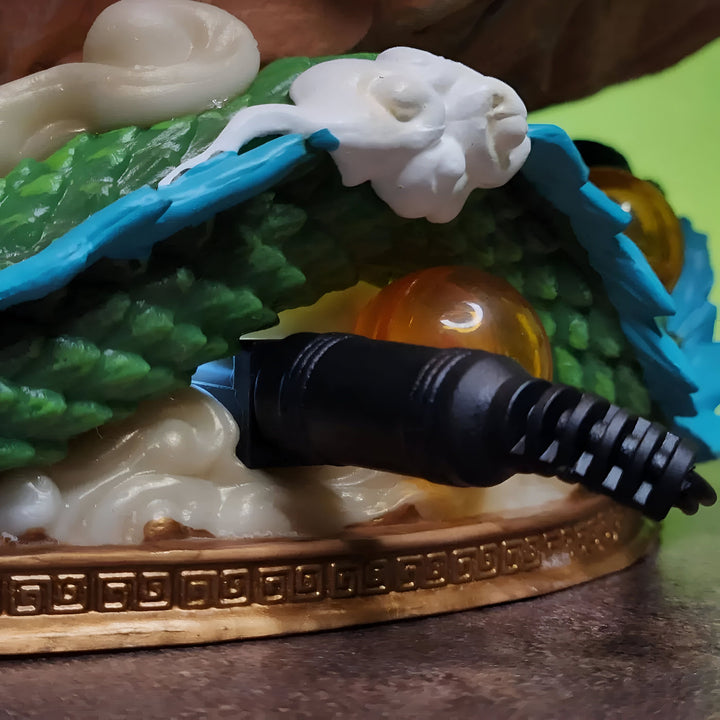 Une image d'un câble d'alimentation noir branché sur une figurine de Shenron, un dragon vert et blanc.,FI-7135372719