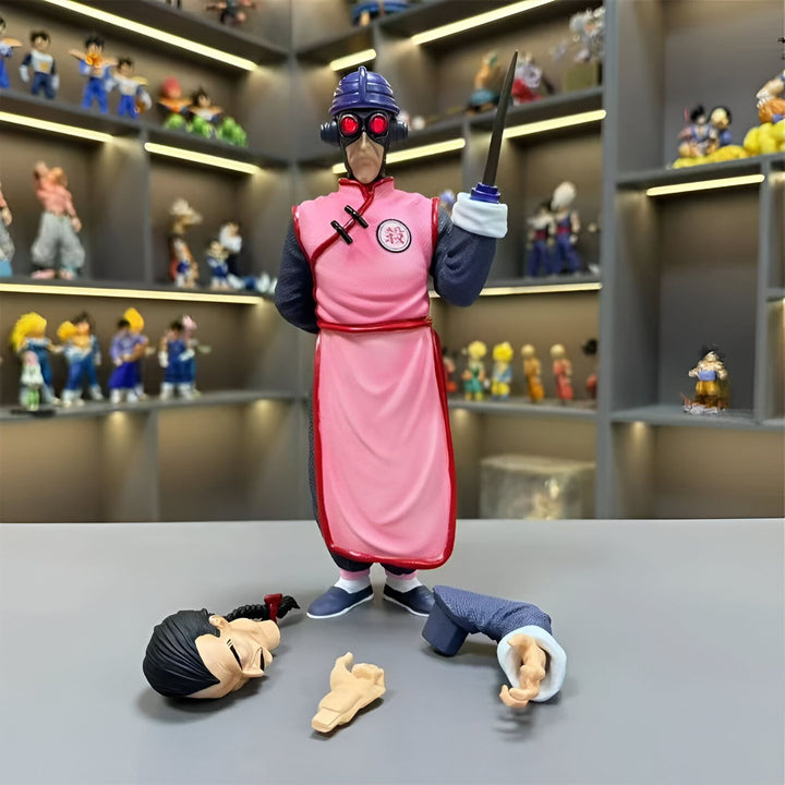 Une figurine de Tao Pai Pai, un personnage de Dragon Ball, est debout sur une table. Il porte une combinaison rose et un casque noir avec des lunettes rouges. Il tient un couteau à la main et regarde vers le bas. À ses pieds se trouvent les restes de ses victimes.,FI-0477108385