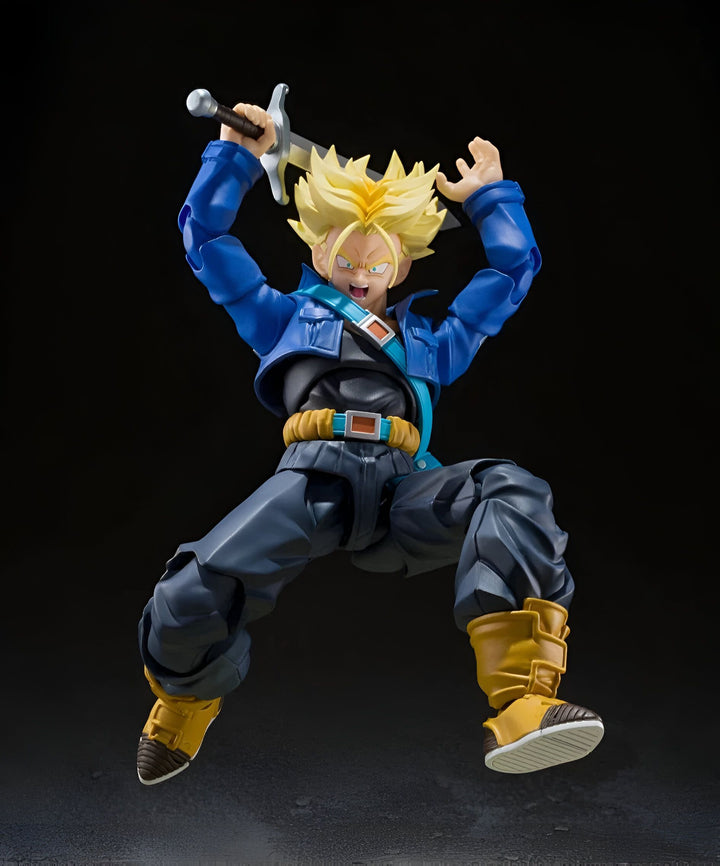 Une figurine de Trunks du futur, un personnage de Dragon Ball Z, brandissant une épée. Il porte une veste bleue, un jean et des bottes jaunes. Il a les cheveux blonds et les yeux bleus. Il est en position de combat, prêt à attaquer.,FI-2109705310
