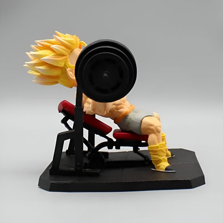 Une figurine de Son Goku en train de soulever des poids. Il est assis sur un banc de musculation et porte un débardeur gris et un short jaune. Il a les cheveux blonds et les yeux bleus. La figurine est en PVC et mesure environ 15 cm de haut.,FI-9270442446