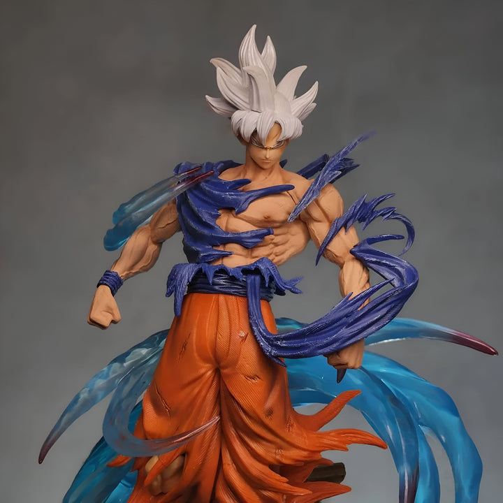 Une figurine de Son Goku, un personnage de Dragon Ball Z. Il est représenté avec les cheveux blancs et les yeux bleus, et porte une combinaison orange et bleue déchirée. Il est en position de combat, avec les poings serrés et les jambes écartées.,FI-544095855X