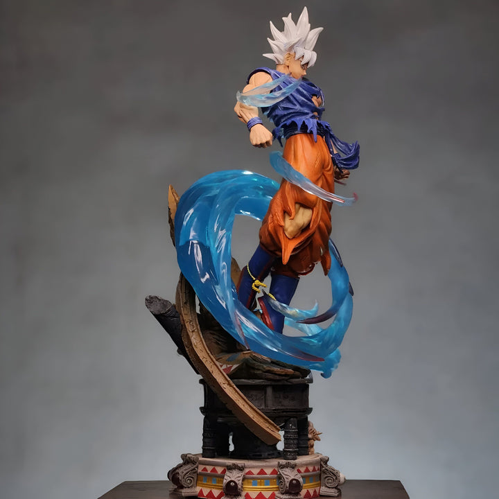 Une figurine de Son Goku, un personnage de la série animée Dragon Ball Z. Il est représenté en train de se battre, avec ses cheveux blancs et bleus hérissés, et une aura bleue l'entourant. Il est vêtu d'un pantalon orange et d'une chemise bleue déchirée. La figurine est posée sur un socle marron et mesure environ 30 cm de haut.,FI-544095855X