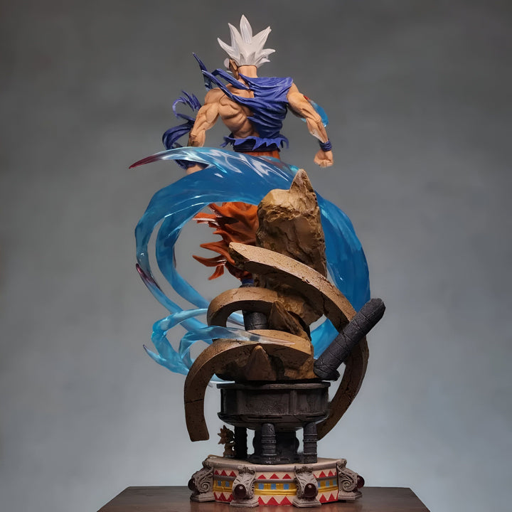 Une figurine de Son Goku, un personnage de la série animée Dragon Ball Z. Il est représenté en train de se battre, avec ses cheveux bleus hérissés et une aura bleue autour de lui. Il est vêtu d'un kimono bleu et blanc déchiré, et il est pieds nus. La figurine est posée sur un socle marron et doré.,FI-544095855X