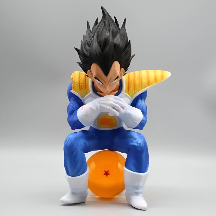 Une figurine de Vegeta, un personnage de la série Dragon Ball Z. Il est assis sur une boule de cristal et porte sa combinaison bleue et jaune. Il a les cheveux noirs et les yeux bleus.,FI-0289673437