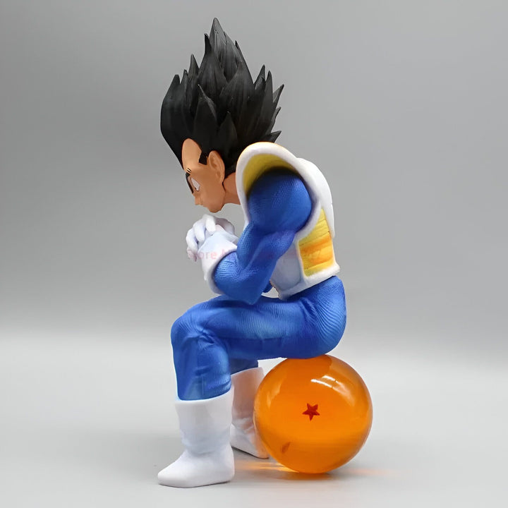 Une figurine de Vegeta, un personnage de la série Dragon Ball Z. Il est assis sur une boule de cristal et porte sa combinaison de combat bleue et jaune. Il a les cheveux noirs et les yeux bleus.,FI-0289673437