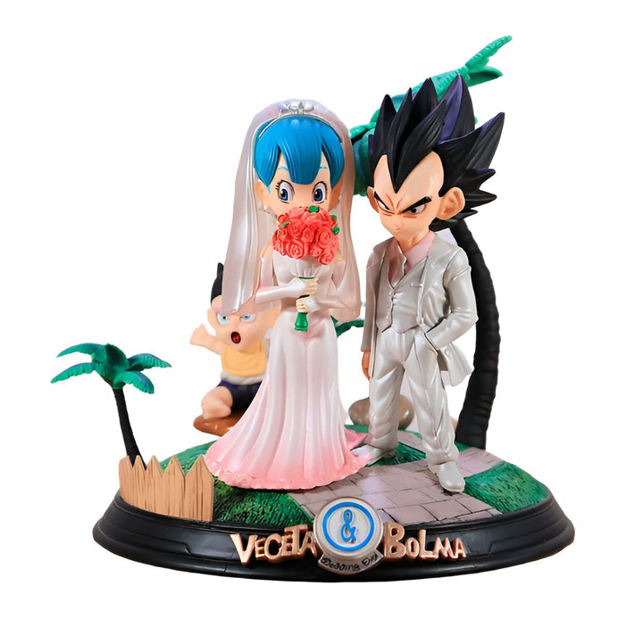 Cette image représente un gâteau de mariage surmonté de figurines de Vegeta et Bulma, deux personnages de la série animée Dragon Ball Z. Vegeta est vêtu d'un costume blanc et Bulma d'une robe de mariée blanche. Le gâteau est décoré de fleurs roses et de feuillage vert. En arrière-plan, on peut apercevoir une clôture en bois et des palmiers.,FI-7990015196