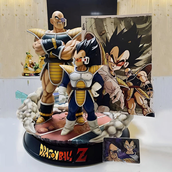 Une figurine de Nappa et Vegeta, deux personnages de la série Dragon Ball Z. Nappa est un grand homme chauve avec une moustache et une barbiche. Il porte une armure violette et noire. Vegeta est un homme de taille moyenne avec des cheveux noirs et des yeux bleus. Il porte une armure bleue et jaune. Les deux personnages sont debout sur un socle rond.,FI-3326150202