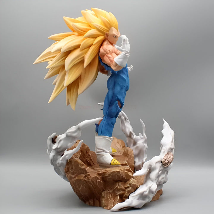 Une figurine de Vegeta, un personnage de Dragon Ball Z, est debout sur un rocher. Il est vêtu d'une combinaison bleue et jaune et a les cheveux longs et blonds. Il est en position de combat et semble prêt à attaquer.,FI-9370504788