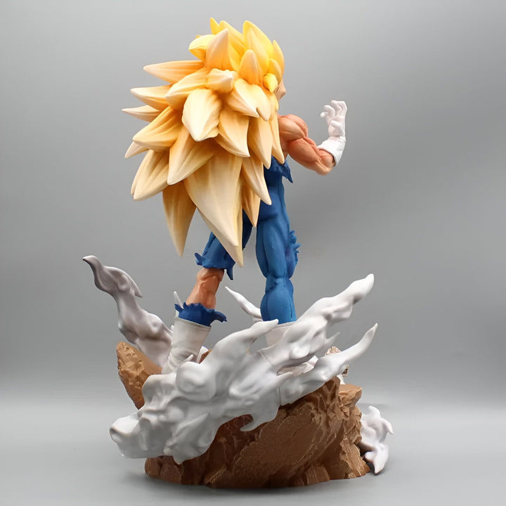 Une figurine de Vegeta, un personnage de Dragon Ball Z, est debout sur un rocher. Il est vêtu d'une combinaison bleue et jaune et a les cheveux longs et blonds. Il est en position de combat et semble prêt à attaquer.,FI-9370504788