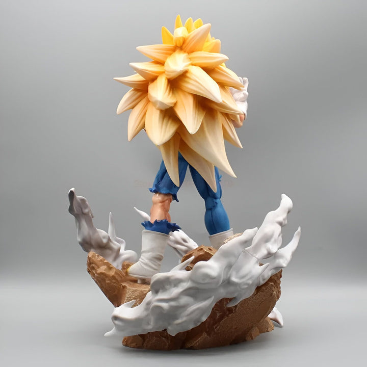 Une figurine de Vegeta, un personnage de Dragon Ball Z, est debout sur un rocher. Il est vêtu d'une combinaison bleue et jaune et a les cheveux longs et blonds. Il est en position de combat et semble prêt à attaquer.,FI-9370504788