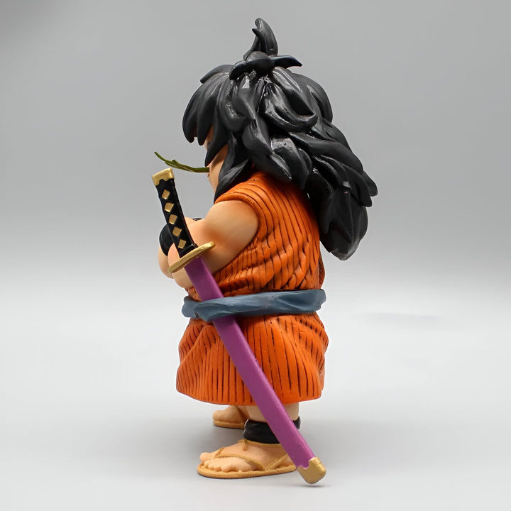 Une figurine de Yajirobé, un personnage de Dragon Ball, est représentée de profil. Il porte un kimono orange et tient un sabre dans sa main droite. Il a les cheveux longs et noirs et porte des sandales.,FI-546999421X