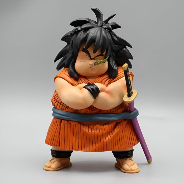 Une figurine en plastique du personnage Yajirobé de la série Dragon Ball Z. Il est représenté avec un air arrogant, les bras croisés sur son ventre, et porte une épée violette à la hanche. Il a les cheveux noirs et porte une tenue orange et bleue.,FI-546999421X