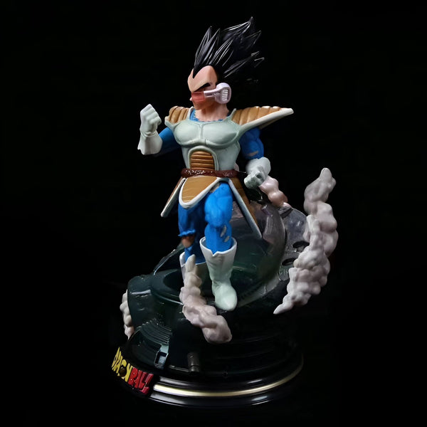 Une figurine de Vegeta, un personnage de Dragon Ball Z, debout sur un socle noir et doré. Vegeta est vêtu d'une combinaison bleue et jaune et a les cheveux noirs. Il est en position de combat, le poing droit levé et la jambe gauche en avant.,FI-8019288201