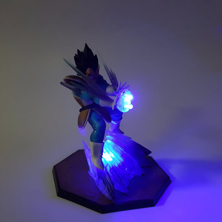 Une figurine de Vegeta, un personnage de Dragon Ball Z, en train de charger son attaque ultime, le Final Flash. La figurine est éclairée par une lumière bleue.,FI-4208578211