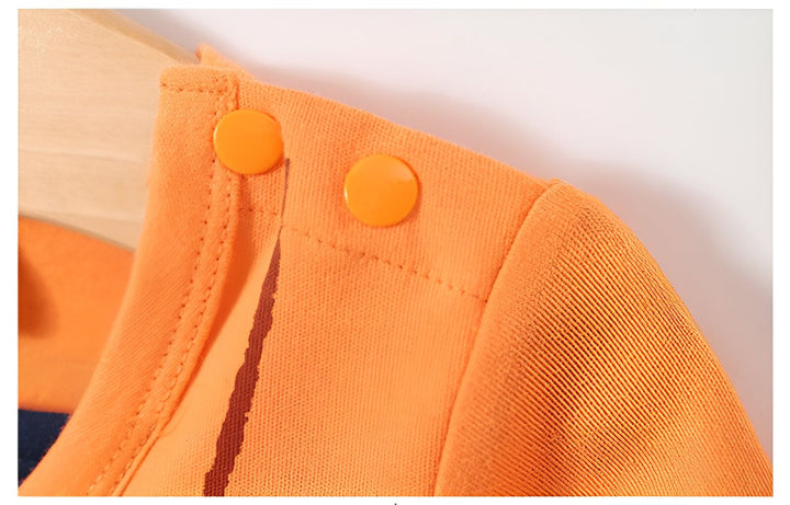 Boutons oranges sur l'épaule d'un vêtement pour enfant.,GR-3241219798,GR-1570201455,GR-0580690407,GR-0058999736,GR-5835771401