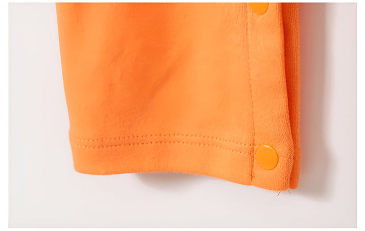 Une image d'un bouton orange sur un vêtement orange.,GR-3241219798,GR-1570201455,GR-0580690407,GR-0058999736,GR-5835771401