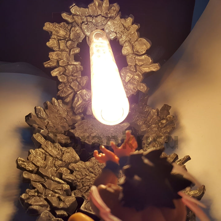 Une lampe en forme de rocher avec une lumière brillante au centre. Un personnage de dessin animé, Goku, est suspendu en l'air, essayant d'atteindre la lumière.,LA-7747466544
