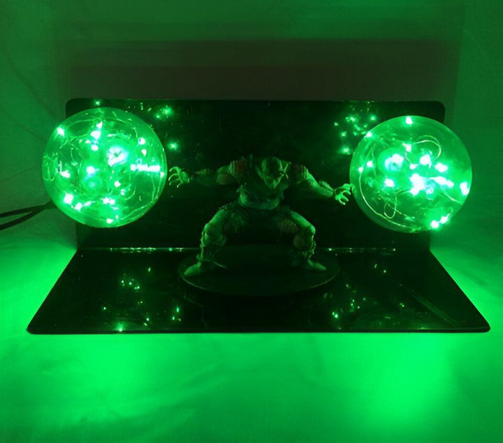 L'image représente une figurine d'un personnage de manga en train de tirer deux boules d'énergie verte. La figurine est éclairée par une lumière verte et est posée sur un socle transparent. En arrière-plan, on peut voir un mur vert.,LA-8832984393