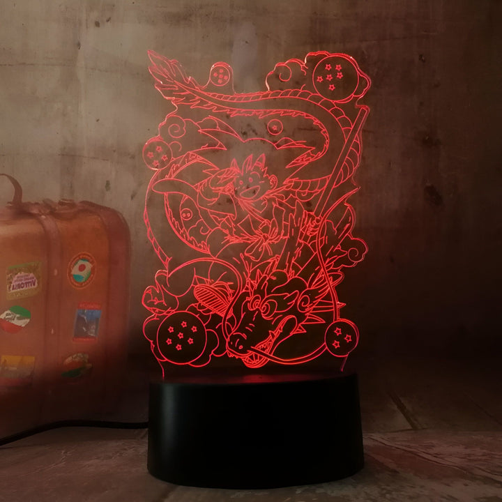 L'image représente une lampe 3D de Son Goku, un personnage de la série animée Dragon Ball Z. Il est assis sur le dragon Shenron, entouré de boules de cristal. La lampe est éclairée par une lumière rouge.,LA-9210201272
