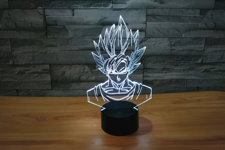 Une image d'une lampe 3D de Son Goku, un personnage de la série animée Dragon Ball Z. La lampe est posée sur une table en bois et est éclairée par une lumière blanche.,LA-2426691638