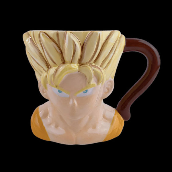 Une tasse en céramique en forme de la tête de Son Goku, un personnage de la série animée Dragon Ball Z. La tasse est jaune et orange, avec les cheveux jaunes de Son Goku et ses yeux bleus. La tasse a une anse marron en forme de queue de singe.,MU-3967866106