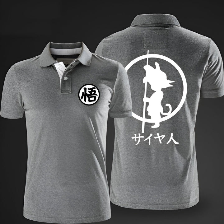 L'image représente un t-shirt gris avec un col polo. Sur le devant du t-shirt, il y a un petit logo rond avec le kanji "goku" écrit en noir. Au dos du t-shirt, il y a une image de Son Goku, un personnage de la série animée Dragon Ball Z. Il est représenté en train de tenir un bâton et de voler. Le texte "saiyan" est écrit en japonais en dessous de l'image.