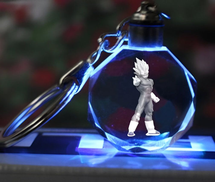 Un porte-clés en cristal avec une figurine de Vegeta, un personnage de la série Dragon Ball Z. La figurine est éclairée par une lumière bleue.,PO-3390394826