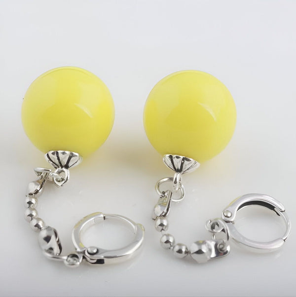 Une paire de boucles d'oreilles en forme de boules jaunes avec une chaîne et un fermoir en argent.,PO-8112919321