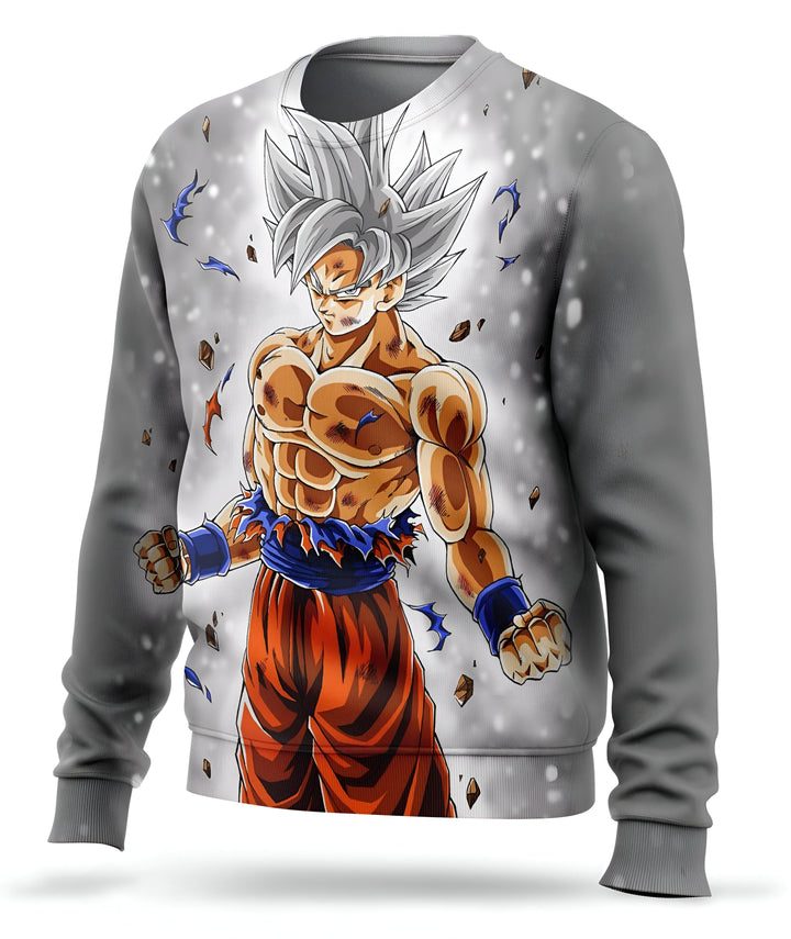 L'image représente un pull-over gris avec un personnage de dessin animé, Son Goku, de la série Dragon Ball Z. Il est vêtu d'un pantalon orange et d'une chemise bleue déchirée, et a les cheveux blancs hérissés. Il est en position de combat, le poing droit en avant et le gauche replié près du corps. Le fond est blanc avec des éclats de pierre qui semblent voler dans toutes les directions.