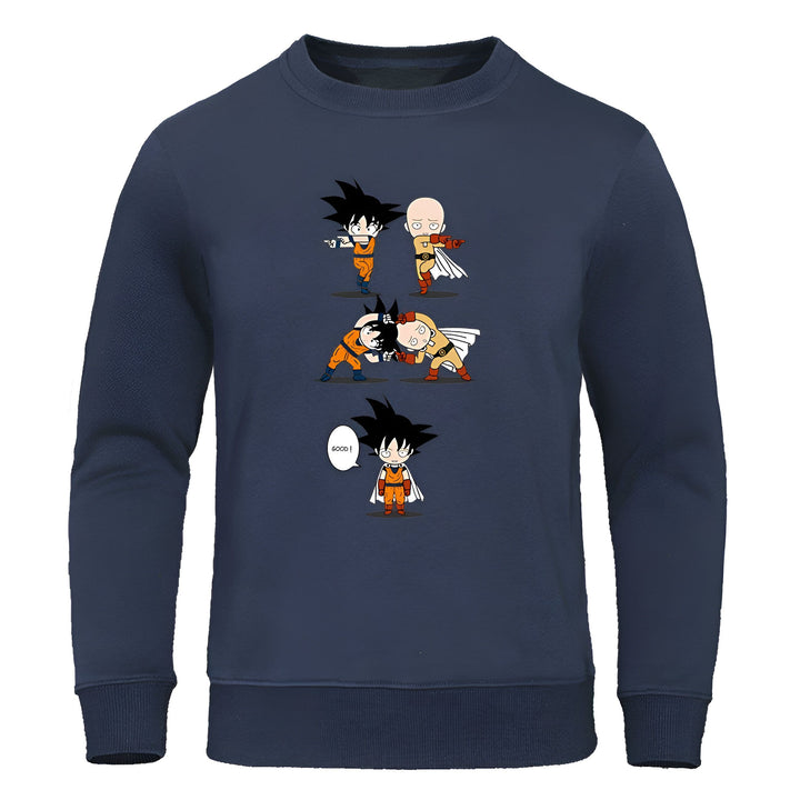 Le pull-over bleu marine présente un design inspiré des dessins animés japonais. On y voit Saitama, le protagoniste de la série One Punch Man, en train de combattre Goku, le personnage principal de la série Dragon Ball Z. Saitama est représenté avec un visage impassible et Goku est représenté avec un visage surpris. Le texte "Good" est écrit en anglais dans une bulle à côté de Saitama.