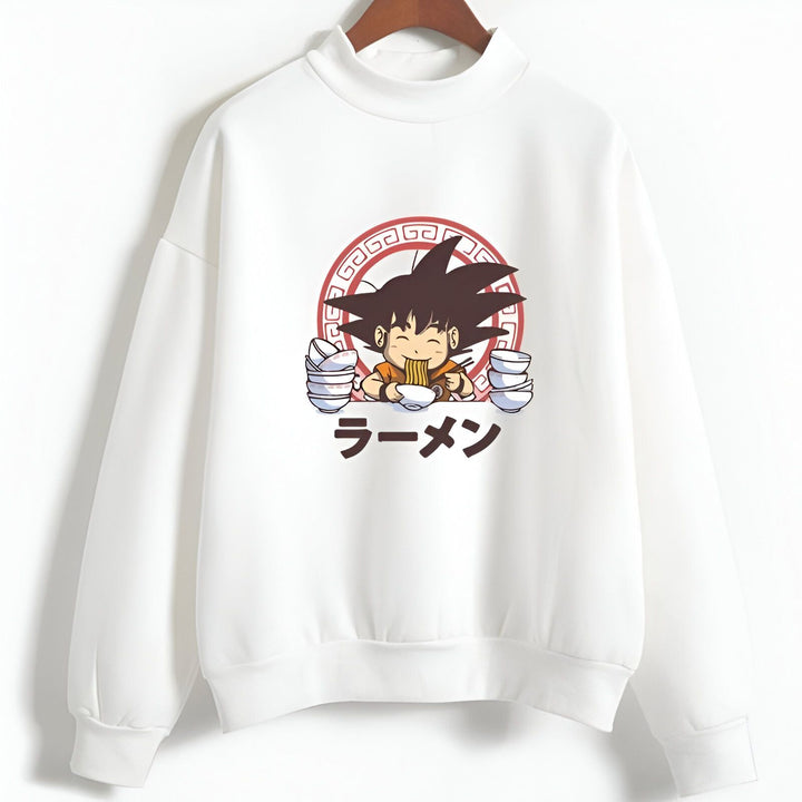 L'image représente un sweat-shirt blanc avec un col montant. Sur le sweat-shirt, il y a un dessin de Son Goku, un personnage de la série animée Dragon Ball Z. Son Goku est en train de manger un bol de ramen, un plat japonais composé de nouilles, de bouillon et de viande. Le texte "ラーメン" (ramen) est écrit en japonais en rouge sur le sweat-shirt.