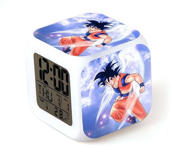 L'image montre un réveil numérique avec une lumière LED. Le réveil est blanc avec une image de Son Goku, un personnage de la série animée Dragon Ball Z. L'écran du réveil affiche l'heure, la date et la température.,RS-7199357427