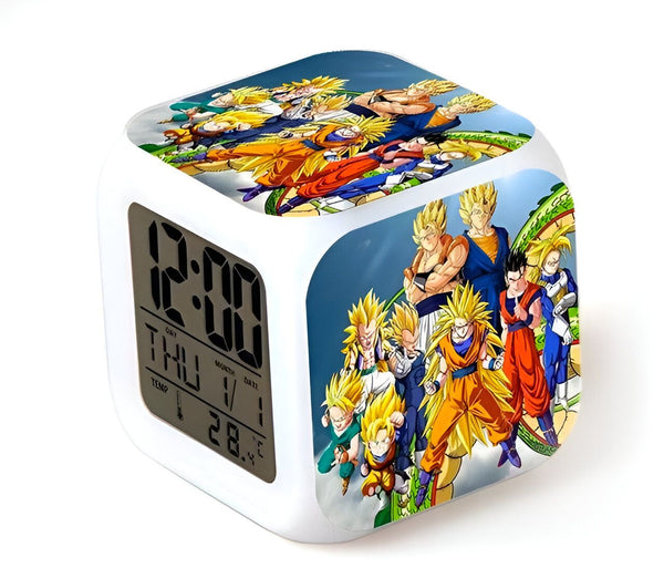 L'image montre un réveil lumineux avec les personnages du dessin animé Dragon Ball Z. Le réveil est blanc avec un écran digital qui affiche l'heure, la date et la température. Les personnages de Dragon Ball Z sont représentés sur le devant du réveil.,RS-513549927X