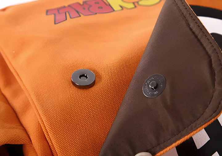 L'image montre un sac à dos orange et marron avec un motif Dragon Ball Z. Le sac à dos est ouvert et on peut voir l'intérieur marron. Il y a un bouton magnétique noir pour fermer le sac à dos.,SA-5637339694