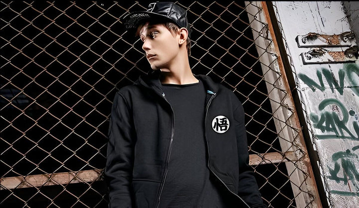 Un jeune homme pose devant un grillage. Il porte une casquette noire, un sweat-shirt noir avec un logo Dragon Ball Z et un jean bleu.,SW-7348963781,SW-510731340X,SW-7832074922,SW-2788561873,SW-8348151567,SW-8631842095,SW-4425896386,SW-0152531505,SW-1962718662,SW-0398823073,SW-8213031237,SW-386439953X,SW-2877932915,SW-0879710411,SW-9660735693