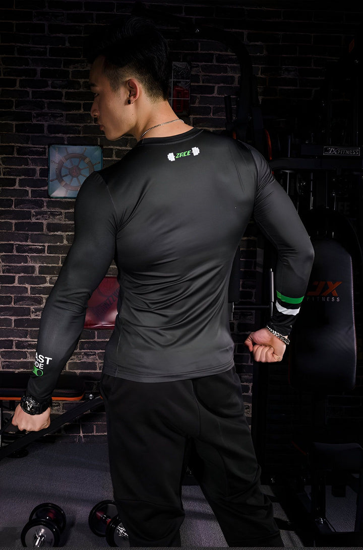 Un homme porte un t-shirt noir et un pantalon de survêtement noir. Il est debout dans une salle de sport, et il est en train de se muscler.,T--9517007175,T--4423494582,T--0416211747,T--9062070795,T--5950953754