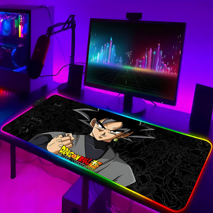 L'image représente un tapis de souris de jeu avec un personnage de l'anime Dragon Ball Super, Goku Black. Le tapis de souris est noir avec un contour lumineux RGB. Il y a un écran d'ordinateur derrière le tapis de souris qui affiche une image de la ville de nuit.,TA-8874816952,TA-9117897378,TA-0634318381